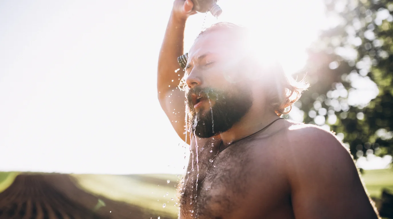 Determined person standing under a cold morning shower with focused breathing