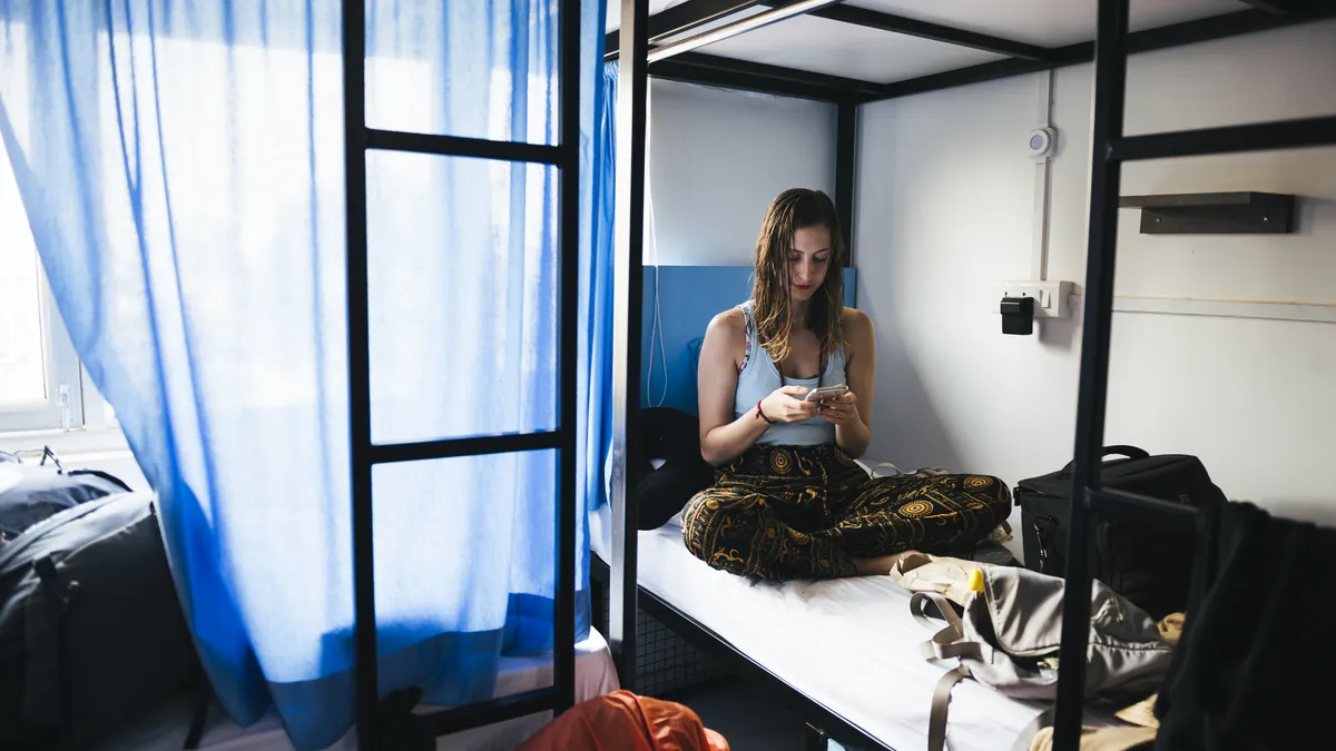 Clean modern hostel dorm room with wooden bunk beds and privacy curtains