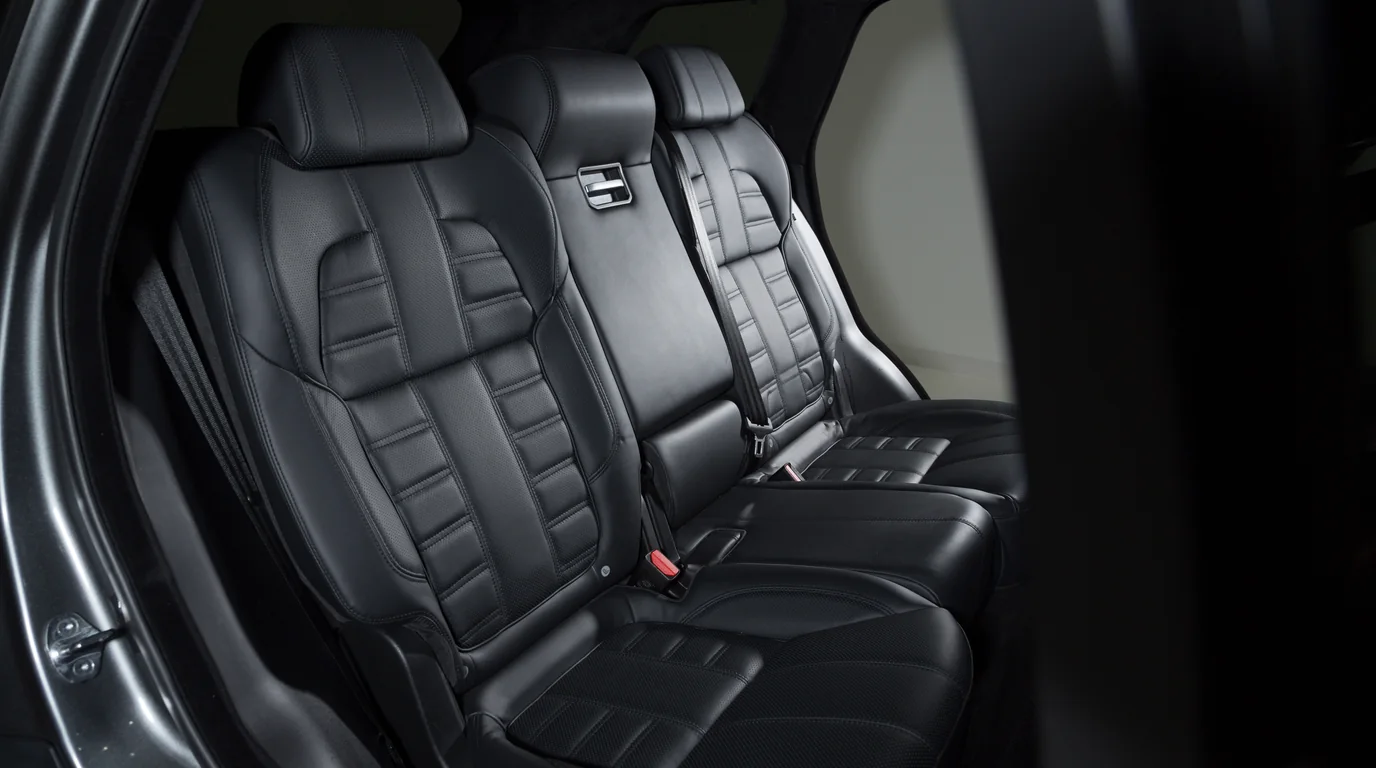 Clean modern car interior showing front leather seats and center console footwell