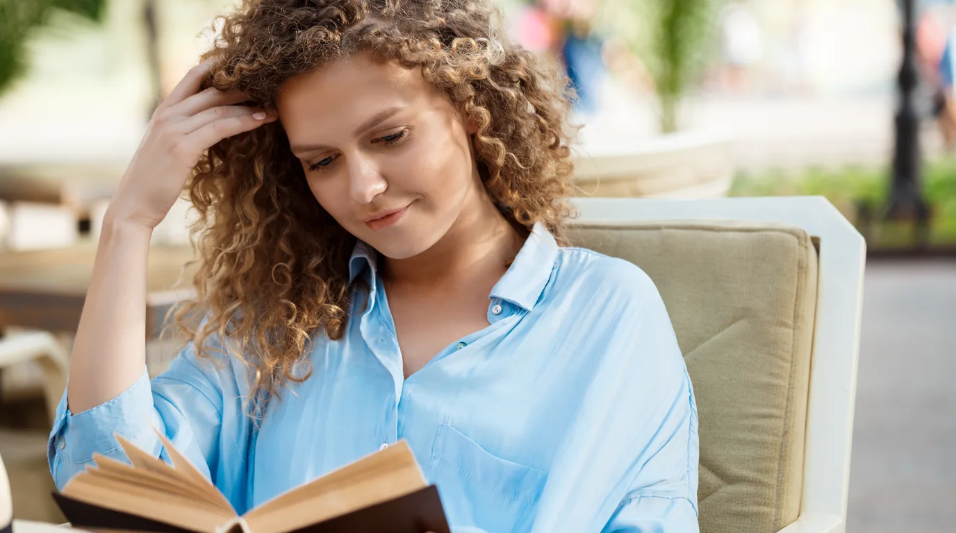 Focused reader in quiet sunlit room practicing deep work without phone distraction