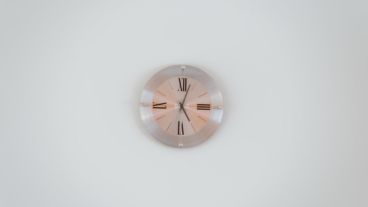 Modern analog wall clock hanging on bedroom wall under optical lens glint inspection